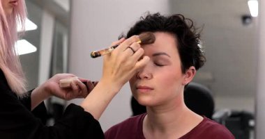 Profesyonel makyöz güzellik salonundaki güzel kadın mankene makyaj yapıyor..                      