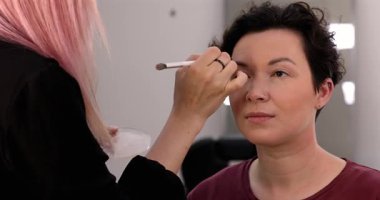 Profesyonel makyöz güzellik salonundaki güzel kadın mankene makyaj yapıyor..                      