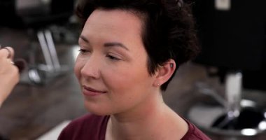 Profesyonel makyöz güzellik salonundaki güzel kadın mankene makyaj yapıyor..                      