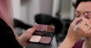 Profesyonel makyöz güzellik salonundaki güzel kadın mankene makyaj yapıyor..                      