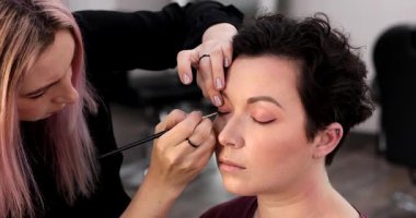 Profesyonel makyöz güzellik salonundaki güzel kadın mankene makyaj yapıyor..                      