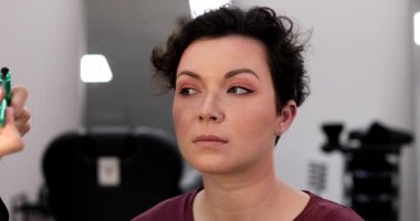 Profesyonel makyöz güzellik salonundaki güzel kadın mankene makyaj yapıyor..                      