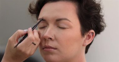 Profesyonel makyöz güzellik salonundaki güzel kadın mankene makyaj yapıyor..                      