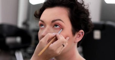 Profesyonel makyöz güzellik salonundaki güzel kadın mankene makyaj yapıyor..                      