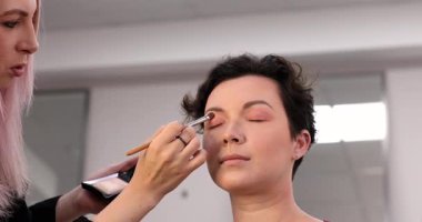 Profesyonel makyöz güzellik salonundaki güzel kadın mankene makyaj yapıyor..                      