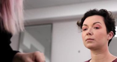 Profesyonel makyöz güzellik salonundaki güzel kadın mankene makyaj yapıyor..                      