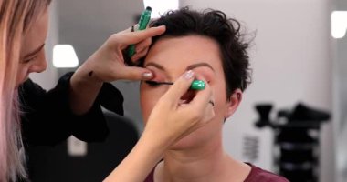 Profesyonel makyöz güzellik salonundaki güzel kadın mankene makyaj yapıyor..                      