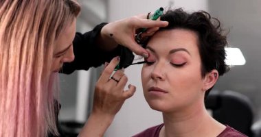 Profesyonel makyöz güzellik salonundaki güzel kadın mankene makyaj yapıyor..                      