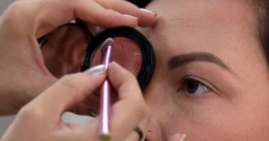 Profesyonel makyöz güzellik salonundaki güzel kadın mankene makyaj yapıyor..                      