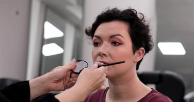 Profesyonel makyöz güzellik salonundaki güzel kadın mankene makyaj yapıyor..                      