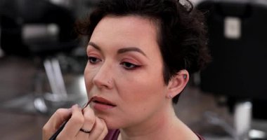 Profesyonel makyöz güzellik salonundaki güzel kadın mankene makyaj yapıyor..                      