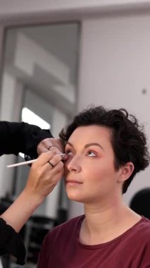 Profesyonel makyöz güzellik salonundaki güzel kadın mankene makyaj yapıyor..                      