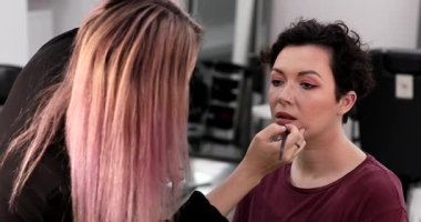 Profesyonel makyöz güzellik salonundaki güzel kadın mankene makyaj yapıyor..                      