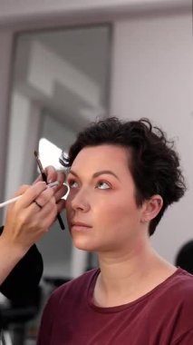 Profesyonel makyöz güzellik salonundaki güzel kadın mankene makyaj yapıyor..                      