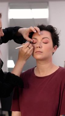 Profesyonel makyöz güzellik salonundaki güzel kadın mankene makyaj yapıyor..                      