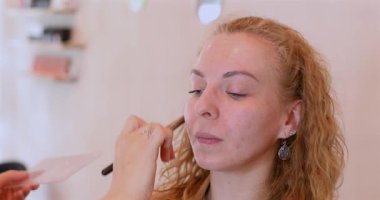 Profesyonel makyöz güzellik salonundaki güzel kadın mankene makyaj yapıyor..                      