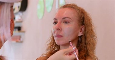 Profesyonel makyöz güzellik salonundaki güzel kadın mankene makyaj yapıyor..                      