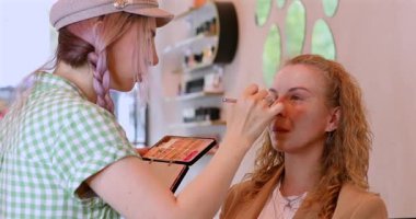 Profesyonel makyöz güzellik salonundaki güzel kadın mankene makyaj yapıyor..                      