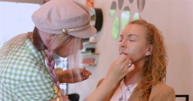 Profesyonel makyöz güzellik salonundaki güzel kadın mankene makyaj yapıyor..                      