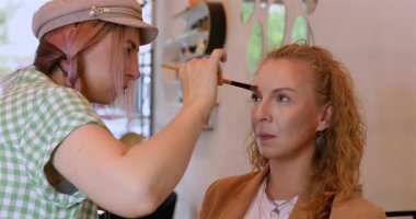 Profesyonel makyöz güzellik salonundaki güzel kadın mankene makyaj yapıyor..                      