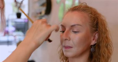 Profesyonel makyöz güzellik salonundaki güzel kadın mankene makyaj yapıyor..                      