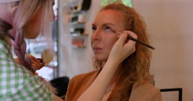 Profesyonel makyöz güzellik salonundaki güzel kadın mankene makyaj yapıyor..                      