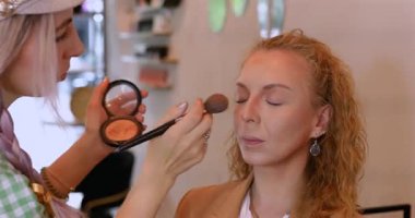Profesyonel makyöz güzellik salonundaki güzel kadın mankene makyaj yapıyor..                      