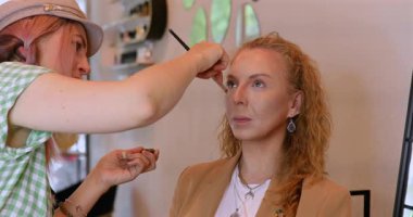 Profesyonel makyöz güzellik salonundaki güzel kadın mankene makyaj yapıyor..                      