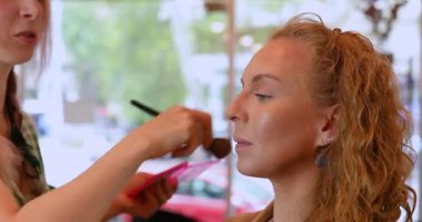 Profesyonel makyöz güzellik salonundaki güzel kadın mankene makyaj yapıyor..                      