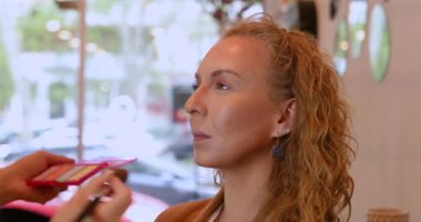 Profesyonel makyöz güzellik salonundaki güzel kadın mankene makyaj yapıyor..                      