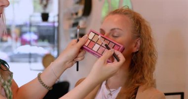 Profesyonel makyöz güzellik salonundaki güzel kadın mankene makyaj yapıyor..                      