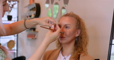 Profesyonel makyöz güzellik salonundaki güzel kadın mankene makyaj yapıyor..                      