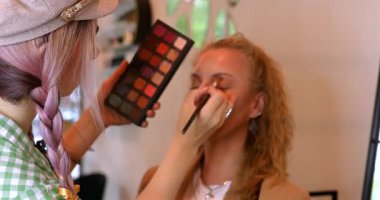 Profesyonel makyöz güzellik salonundaki güzel kadın mankene makyaj yapıyor..                      