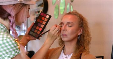 Profesyonel makyöz güzellik salonundaki güzel kadın mankene makyaj yapıyor..                      