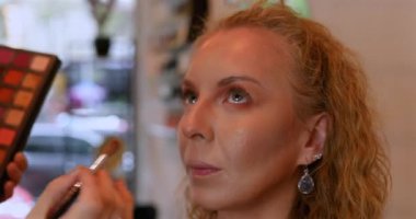 Profesyonel makyöz güzellik salonundaki güzel kadın mankene makyaj yapıyor..                      