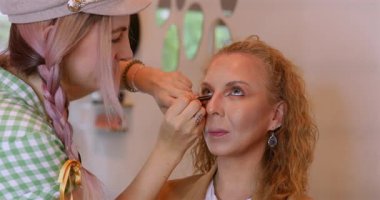 Profesyonel makyöz güzellik salonundaki güzel kadın mankene makyaj yapıyor..                      