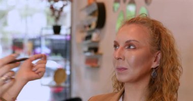 Profesyonel makyöz güzellik salonundaki güzel kadın mankene makyaj yapıyor..                      