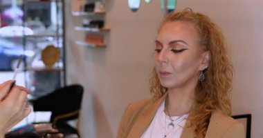 Profesyonel makyöz güzellik salonundaki güzel kadın mankene makyaj yapıyor..                      