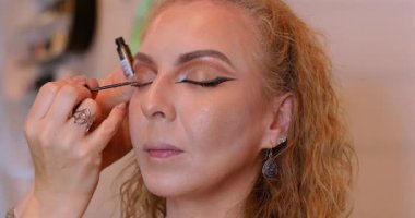 Profesyonel makyöz güzellik salonundaki güzel kadın mankene makyaj yapıyor..                      