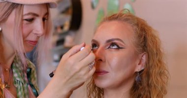 Profesyonel makyöz güzellik salonundaki güzel kadın mankene makyaj yapıyor..                      