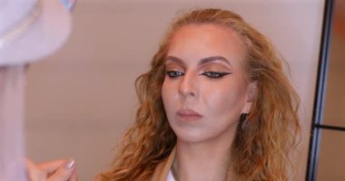 Profesyonel makyöz güzellik salonundaki güzel kadın mankene makyaj yapıyor..                      