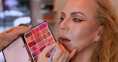 Profesyonel makyöz güzellik salonundaki güzel kadın mankene makyaj yapıyor..                      