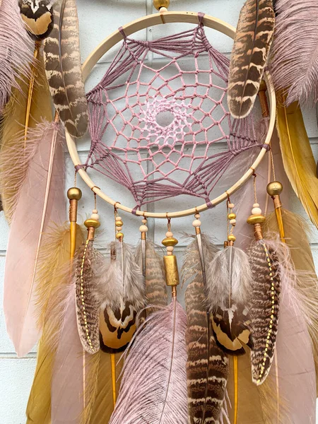 手作りの夢のキャッチャーは 屋外にぶら下がっているキジの羽部族ボヘミアン工芸品の壁でクローズアップ ストック画像