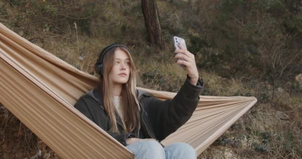 Girl Headphones Listens Music Takes Selfie Phone Hammock Picnic City — Stockvideo