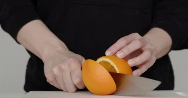 ナイフでオレンジが切れる オレンジジュースの準備 料理人は果物を切ります フルーツサラダを作る人です 高品質4K映像 — ストック動画