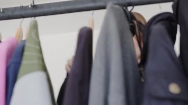 Ayna yansıması genç bir kadın iş günü veya randevu için kıyafet seçiyor, sabahları motive oluyor, soyunma odasında dikiliyor. Giyinmeye çalışan, hafta sonu aktivitesi planlayan mutlu bir milenyum kadını. Yüksek