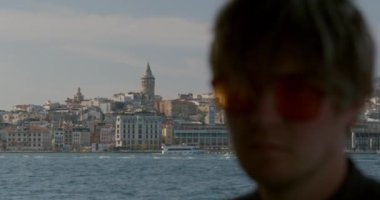 Genç ve şık bir hippi yolcu gemisine biniyor. İstanbul 'da bir feribot geçiyor. Yüksek kalite 4k görüntü