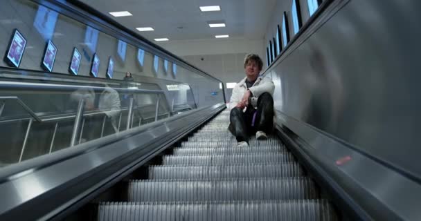 Genç Bir Adam Metroda Bir Yürüyen Merdivenin Basamaklarında Oturuyor Metrodaki — Stok video