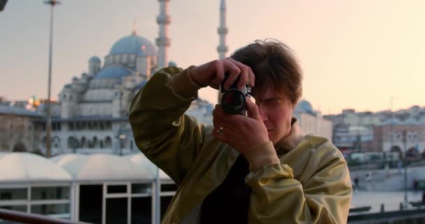 イスタンブールモスクトルコの首都を背景にした若いハンサムな男ヒップスター観光写真 ヒップスターフィルムカメラ写真家 高品質4K映像 — ストック動画