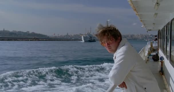 一个年轻时髦的嬉皮士男人骑着客轮横渡大海 一艘渡船驶过 在土耳其伊斯坦布尔的一个场景 高质量的4K镜头 — 图库视频影像